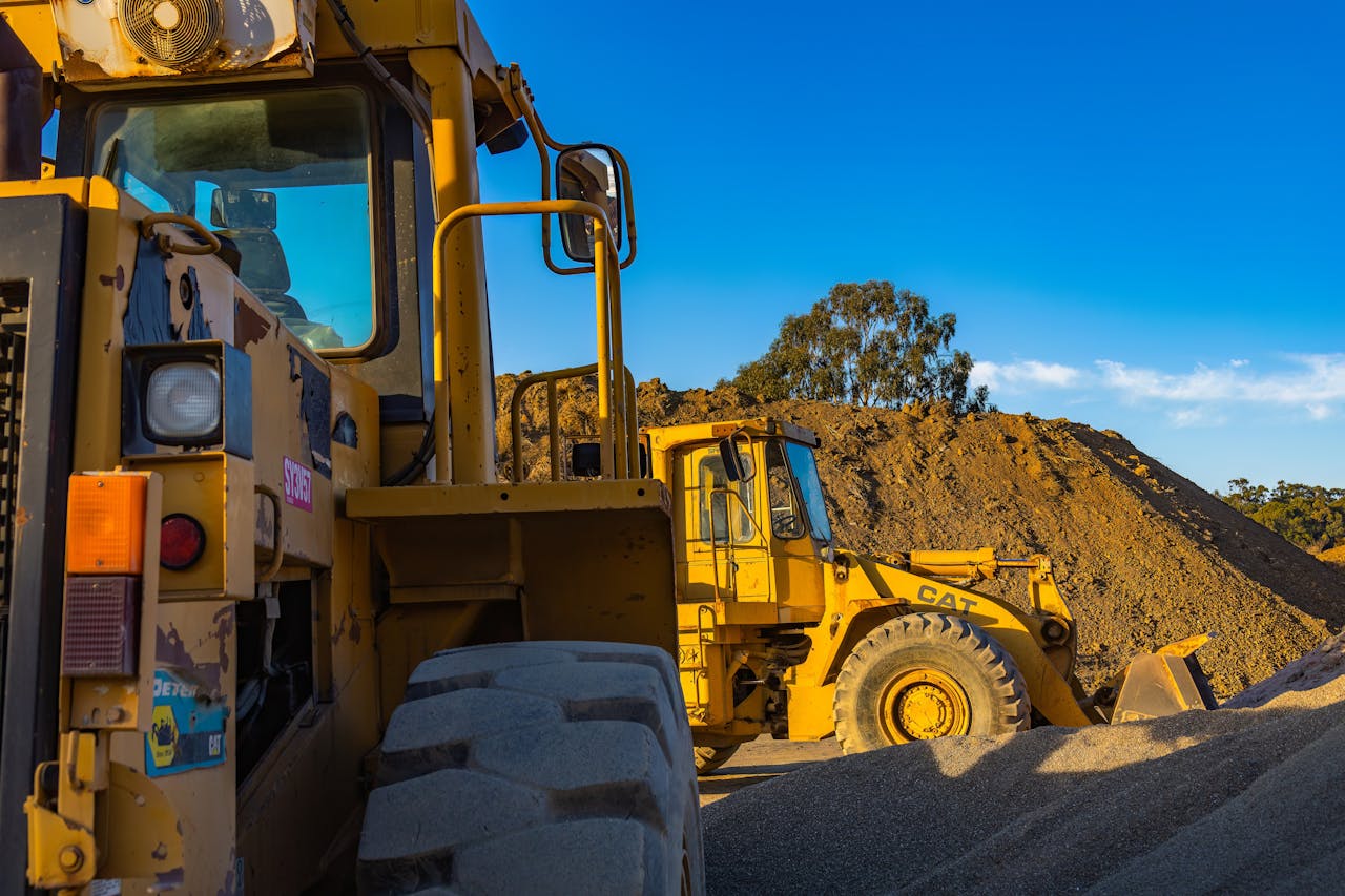 Crafting Captivating Headlines: Your awesome post title goes here Industrial machinery operating outdoors, showcasing a bulldozer and a loader amidst piles of soil.